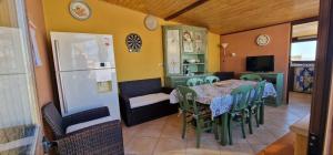 a dining room with a table and chairs and a refrigerator at Al corso 3 in Naro