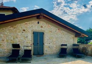 a stone building with chairs on a patio at La Rocchetta B&B in Guiglia