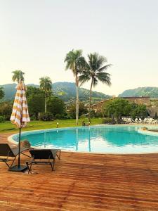 einen Pool mit einem Tisch und einem Sonnenschirm in der Unterkunft Royal Tahitien in Papeete