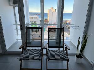 two chairs sitting in front of a large window at Ninfas Plaza in Puerto Madryn