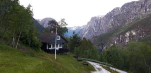 une petite maison sur une colline à côté d'une rivière dans l'établissement Stalheim Fjord og Fjellhytter, à Stalheim