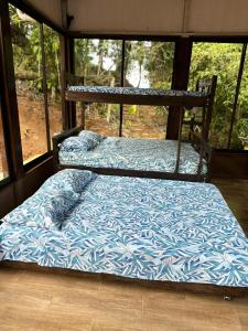 2 camas en una habitación con ventana en Rincón de Goye en Turrialba