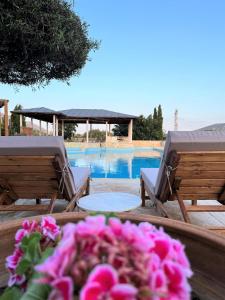a table with flowers in front of a pool at Summer Villa Lagonissi in Lagonissi