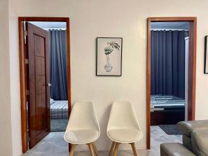 uma sala de estar com duas cadeiras brancas e um espelho em MARLS PLACE FULLY FURNISHED, 4 mins walk to SM MALL and GAISANO MALL FB name Marls Place em Butuan