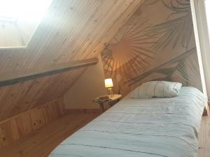Notre nid - Grande terrasse privée en bord de mer, au coeur du quartier historique du Tréport ! في لو تريبور: سرير في غرفة ذات سقف خشبي