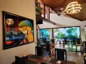 a dining room with a painting of a parrot on the wall at Pousada Costa Del Sol in Búzios