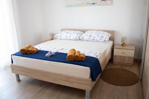 Villa Koraljka في فوديس: غرفة نوم عليها سرير وعليها حذاء