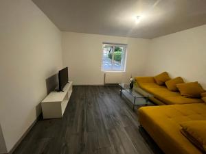a living room with two beds and a flat screen tv at CLAREN appart 57 in Longeville-lès-Saint-Avold