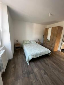 a bedroom with a bed and wooden floors at CLAREN appart 57 