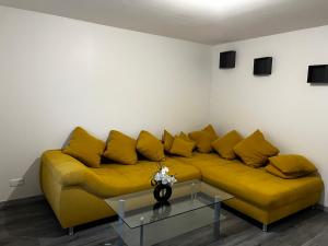 a yellow couch in a living room with a table at CLAREN appart 57 