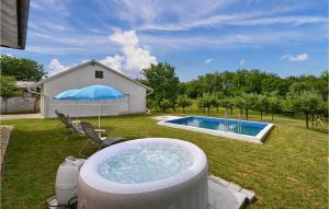 a hot tub in a yard with an umbrella at Lovely Home In Senkovec With Sauna in Slakovec