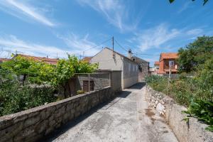 a street in a village with a stone wall at Holiday house with WiFi Sali, Dugi otok - 17797 in Sali