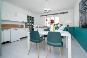 a kitchen with a white table and blue chairs at Holiday house with WiFi Sali, Dugi otok - 17797 in Sali