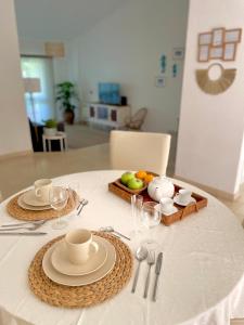 a table with a white table cloth with plates and cups at Detailed Villa - In Vilamoura's Heart in Vilamoura