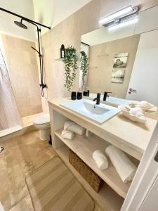 a bathroom with a sink and a toilet and a mirror at Detailed Villa - In Vilamoura's Heart in Vilamoura