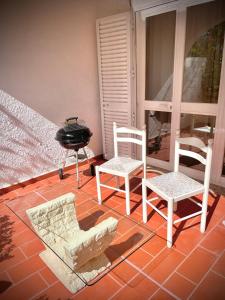 a patio with two chairs and a grill on a patio at Detailed Villa - In Vilamoura's Heart in Vilamoura