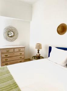 a bedroom with a white bed and a dresser at Detailed Villa - In Vilamoura's Heart in Vilamoura