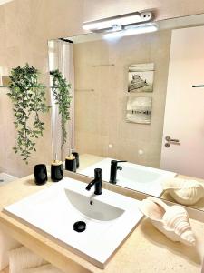 uma casa de banho com um lavatório branco e um espelho. em Detailed Villa - In Vilamoura's Heart em Vilamoura