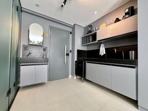 a kitchen with a sink and a mirror at Studio em frente a praia do Bessa in Tambaú