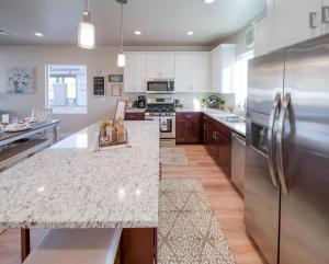 a kitchen with a stainless steel refrigerator and a counter at New South Zion Coral Cliffs - 4 bed, 3 bath, hot tub, deck in Hildale
