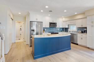 a kitchen with white cabinets and a blue island at Karoll I Unit D in Ocean City