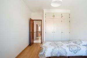 a bedroom with a bed and a closet at Sunny Marisol T2 in Aroeira