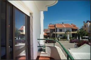 a balcony of a building with a view of a street at Sunny Marisol T2 in Aroeira