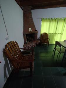 a living room with two chairs and a fireplace at AMALUR in Sañogasta