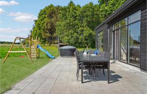 patio con mesa y parque infantil en Gorgeous Home In Grenaa With Sauna, en Brøndstrup
