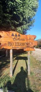 a wooden sign that says no hermoso at Cabañas Rio Hermoso in Cerro Negro