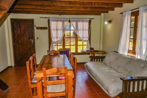 sala de estar con mesa de madera y sofá en Cabañas Rio Hermoso en Cerro Negro