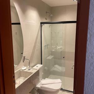 uma casa de banho com um WC e uma cabina de duche em vidro. em Villa Kamby Milagres B004 em São Miguel dos Milagres