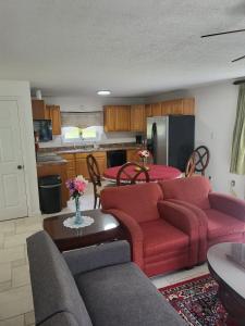 een woonkamer met rode meubels en een keuken bij Pinetree Inn in Parsons