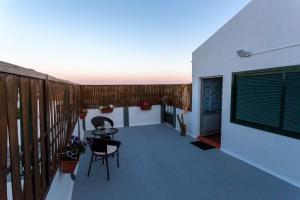 a balcony of a house with a table and chairs at Casa do Calço in Ponta Delgada