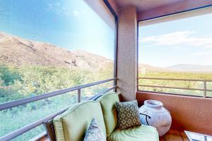 balcón con sofá y ventana grande en Canyon Views Forever en Tucson