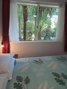 um quarto com uma janela e uma cama com um edredão em Kincumber Guest Suite em Kincumber