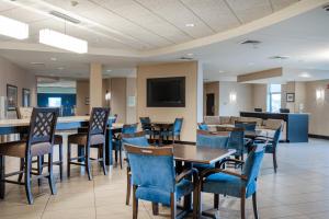 a dining room with tables and chairs and a flat screen tv at Holiday Inn - Terre Haute, an IHG Hotel in Terre Haute