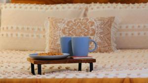 uma caneca de café azul numa mesa ao lado de uma cama em Desert Hideaway - Underground living - White Cliffs em White Cliffs