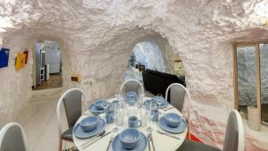 a dining room with a table in a stone wall at Desert Hideaway - Underground living - White Cliffs in White Cliffs