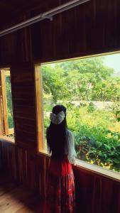 mała dziewczynka patrząca przez okno w obiekcie Tuyet's Homestay w mieście Ninh Binh