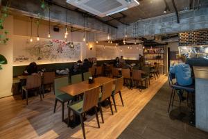 a restaurant with wooden tables and chairs and people sitting at tables at Tanuki Nozawa in Nozawa Onsen