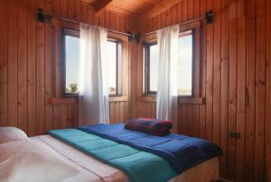 sypialnia z 2 łóżkami i 2 oknami w obiekcie Ocho Aguilas Eco Lodge w mieście Guanaqueros