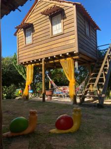 ein Baumhaus mit zwei Gummienten im Hof in der Unterkunft Recanto da Represa Carrancas in Carrancas
