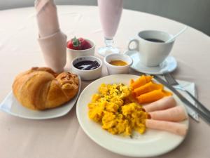 a table with a plate of breakfast foods and a cup of coffee at Suites & Hotel Gonzalez Suarez in Quito