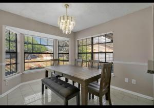 a dining room with a table and chairs and windows at The Cozy spot in Orlando