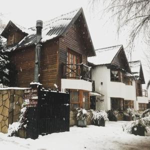 a wooden house with snow on the roof at Holiday Home Las Retamas in San Martín de los Andes