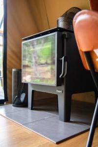 a television sitting on top of a desk with a chair at Moogie Glamp in Moogerah