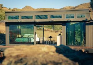 a house with glass doors and a bed in it at Haurapa PurePod in Cromwell