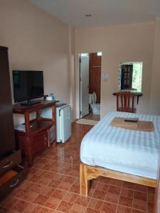 Schlafzimmer mit einem Bett, einem Schreibtisch und einem TV in der Unterkunft Sofia Garden Resort in Ko Chang