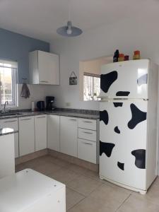 a kitchen with a refrigerator with a cow print on it at Departamento Jardín Malbec!! in Ciudad Lujan de Cuyo